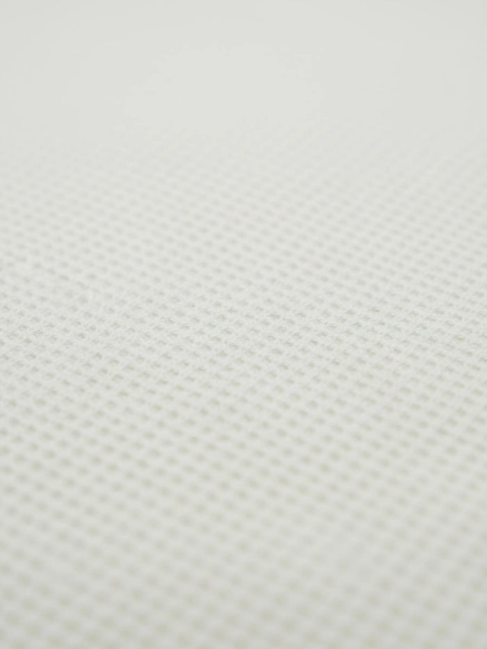 Close-up of off-white waffle knit fabric texture from the Zest sweater.