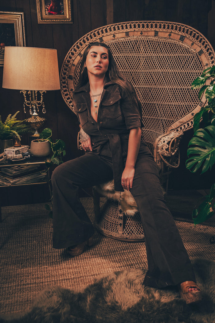 Soulful chocolate corduroy 70s inspired jumpsuit with bell bottom legs and retro silhouette styled with modern accessories for effortless groove