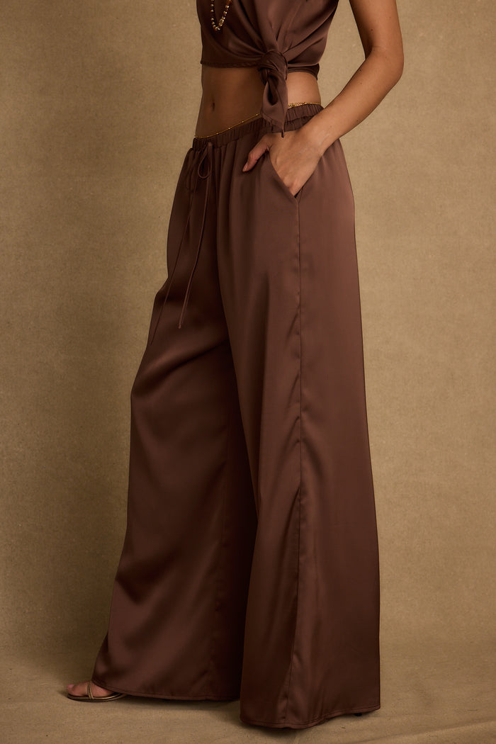 Lifestyle shot of the espresso pants styled for day-to-night versatility.