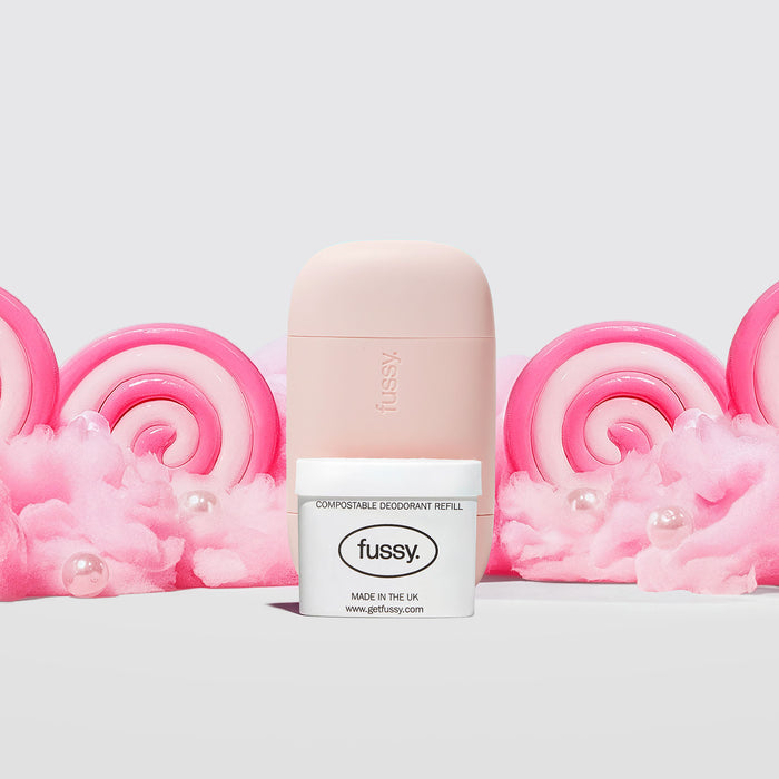 Fussy's Sugar Crush Starter Deodorant Pack featuring a Pale Pink case and one refill pack set against a backdrop of cotton candy and pink and white lollipops