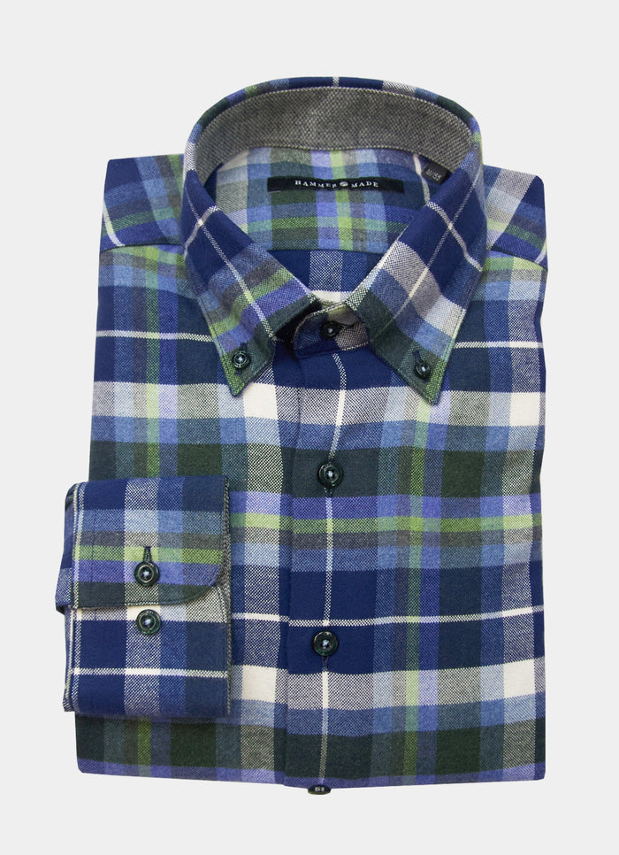 The Weaver Flannel is a folded long-sleeve button-down shirt in a blue, green, white, and gray plaid pattern, crafted from soft Italian fabric.