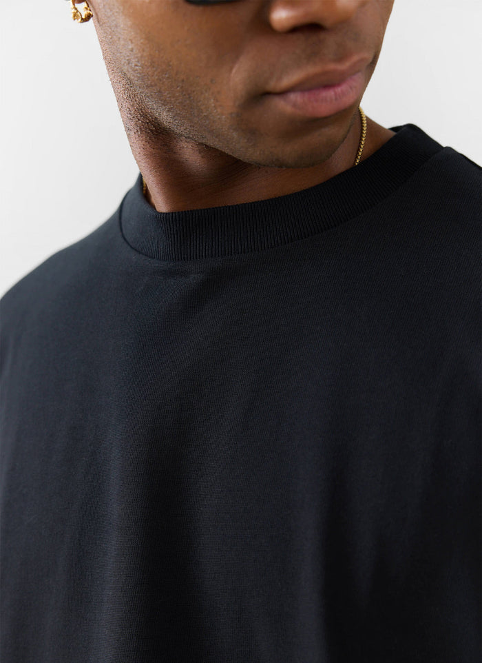 A close-up of the heavyweight organic cotton and ribbed neckline on the black oversized Percival t-shirt.