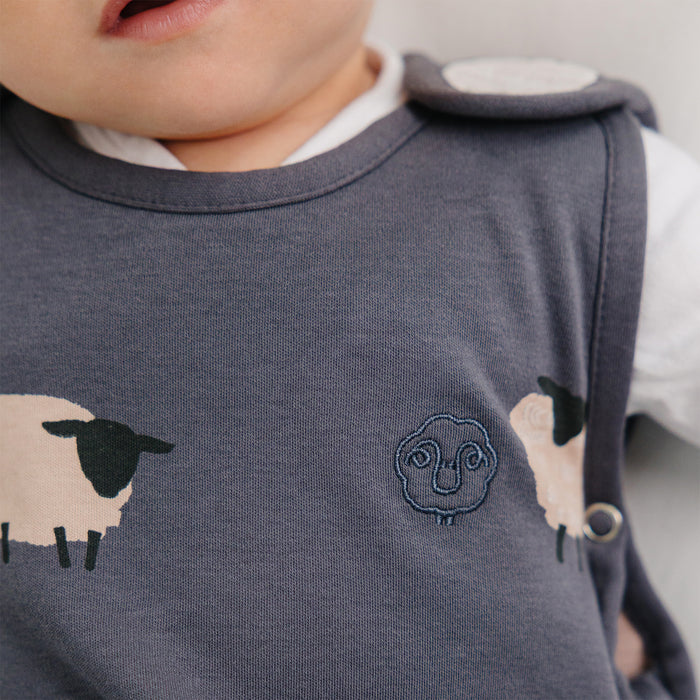 Close-up of a child wearing a Woolino Sleep Bag in Sheep Slate patterns.