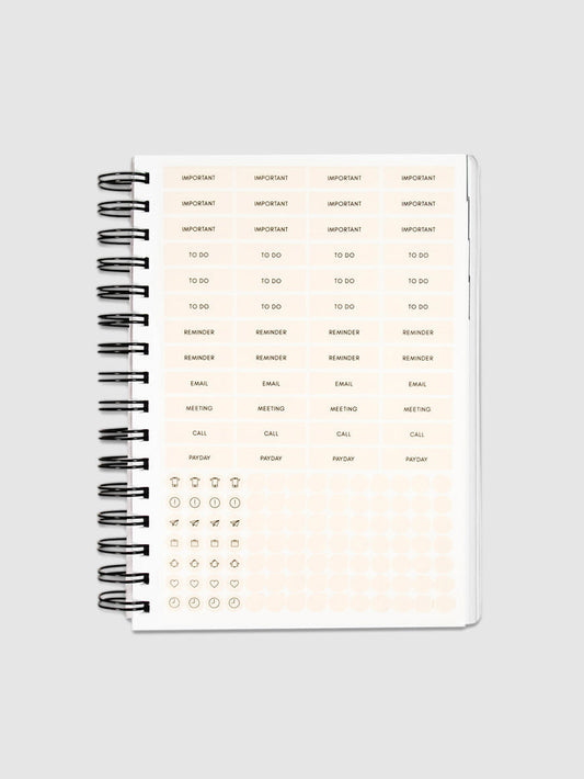 Planner Stickers in a 2022 Spiral Bound Planner on a neutral background