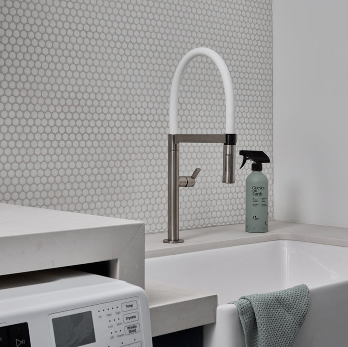 Guests on Earth All-Purpose Cleaner beside a utility sink and washer in a bright laundry room, ready for quick wipe-downs