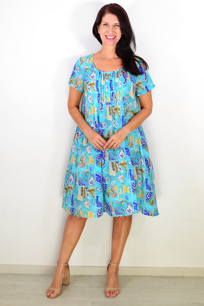 Hourglass Aqua Paisley floral pleated casual tunic dress with a relaxed fit and flowing fabric, displayed on a hanger.
