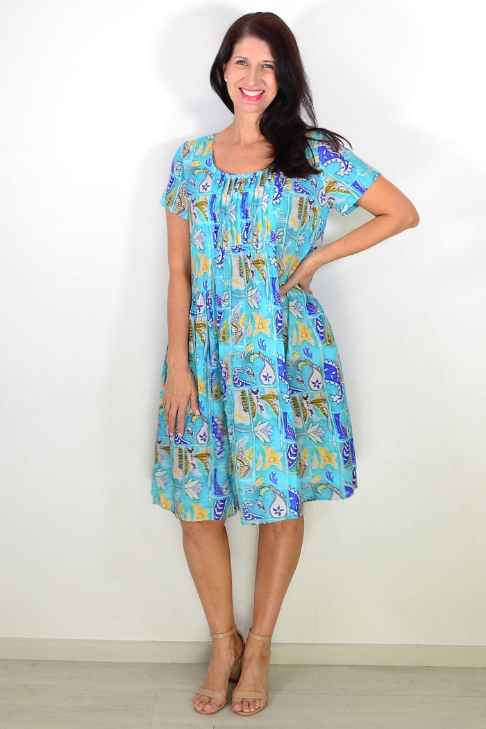 Hourglass Aqua Paisley Floral Pleated Casual Tunic Dress displayed on a hanger with a floral pattern and flowing pleats.