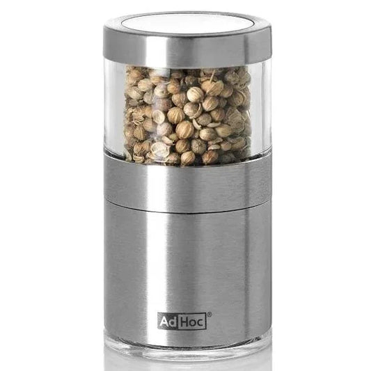 Stainless steel pepper grinder with coriander seeds on a white background