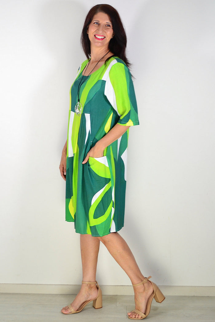 Green and white abstract print tunic dress by Hourglass, showcasing a flowing fabric and stylish design.