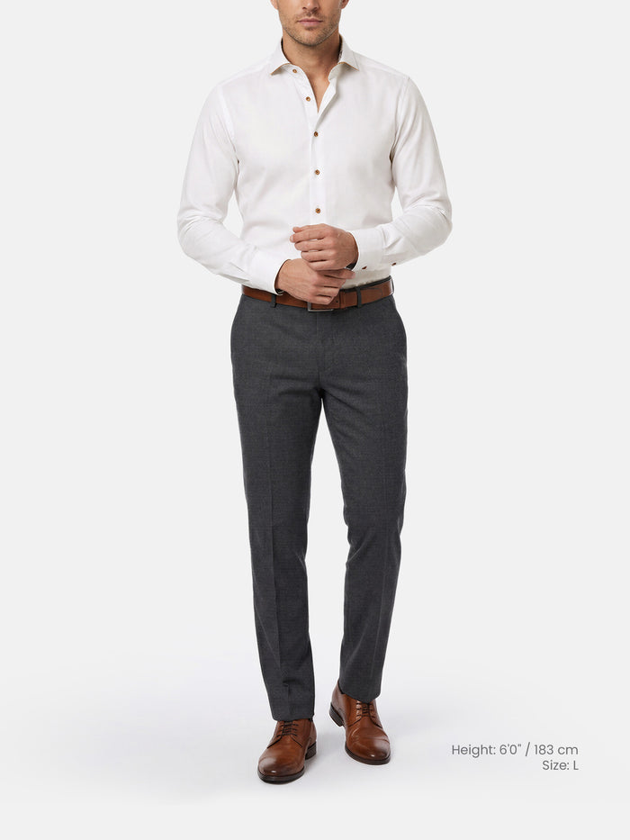 Man wearing a white shirt, gray trousers, and brown shoes on a white background