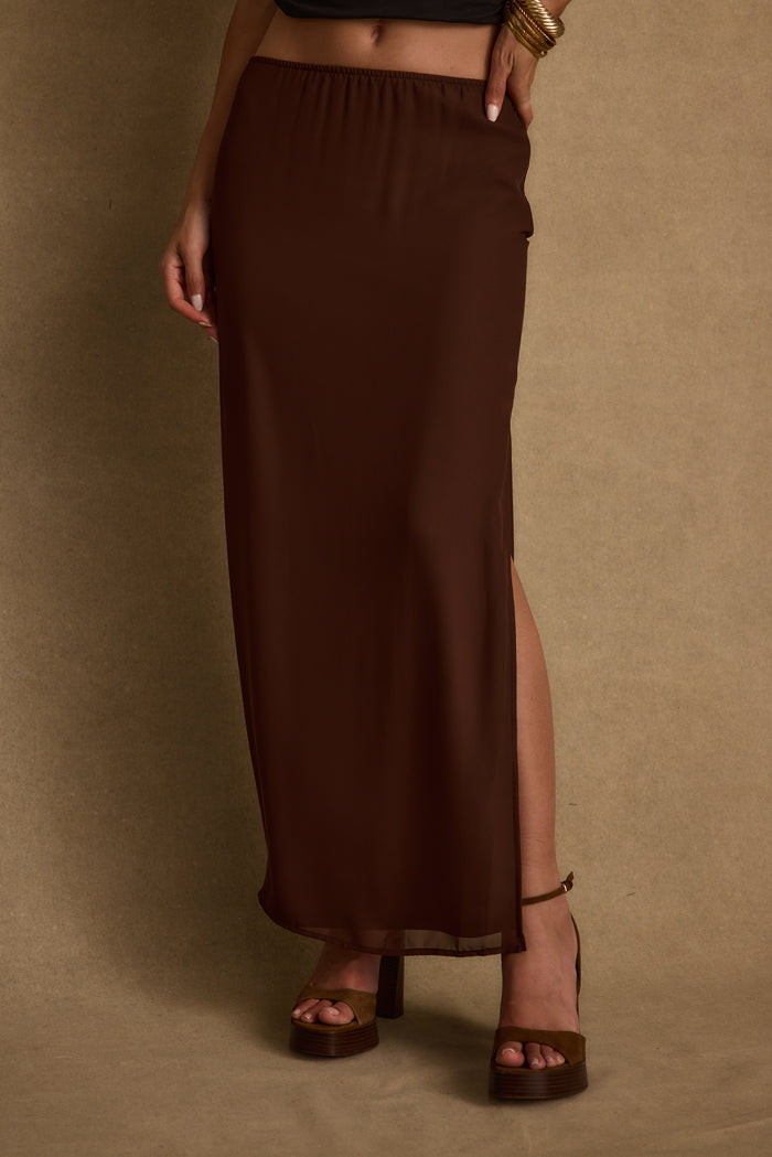 Full-length view of the mocha maxi skirt showing the drape and movement.