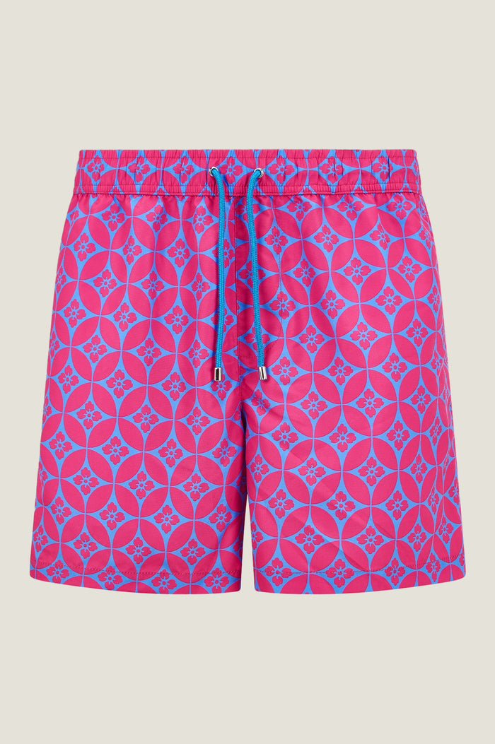 Bright pink and blue patterned swim shorts with drawstring waist, displayed on a white background.