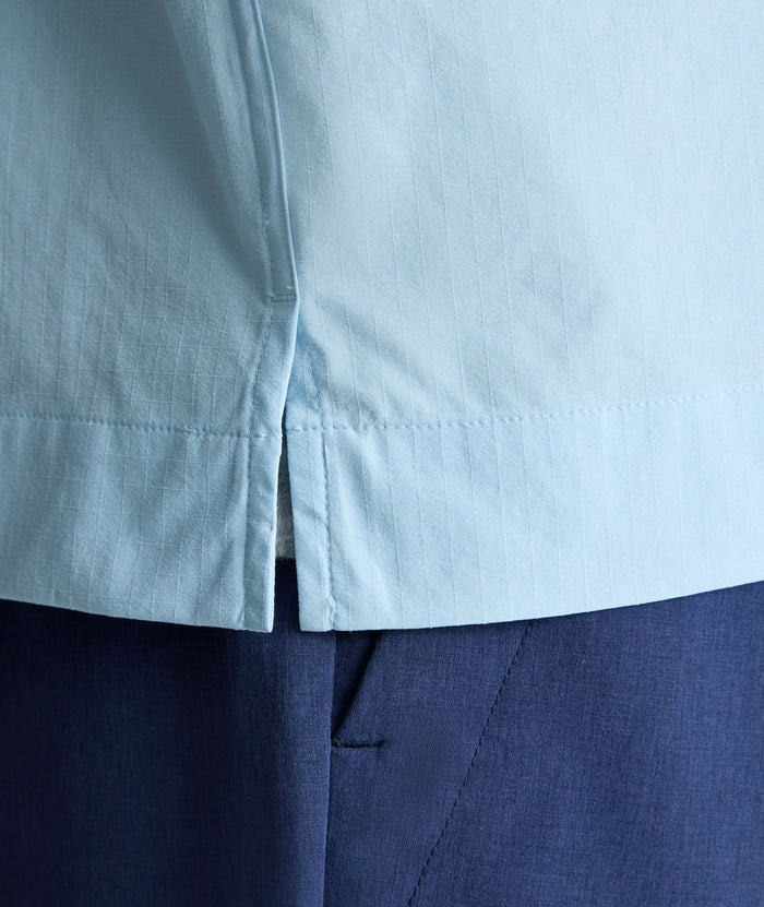 Model is wearing UNTUCKit Performance Fishing Shirt in light blue.