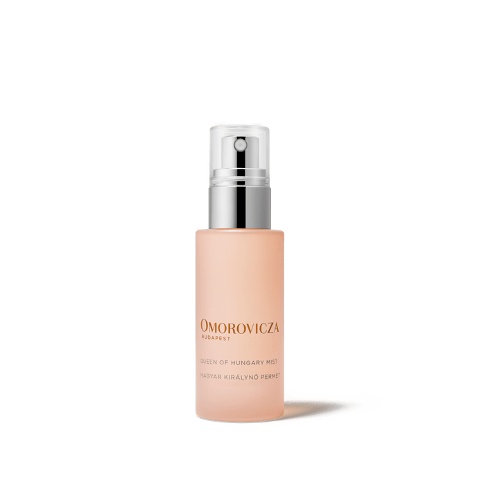 Bottle of Queen of Hungary Mist | Omorovicza facial mist with a minimalist design, featuring a soft peach color and a silver spray cap for skincare and wellness.