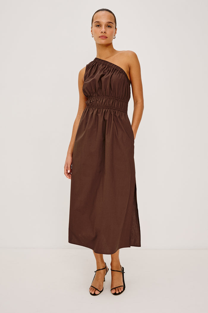 Selani Midi Dress in Cotton Poplin With One-Shoulder Neckline, Shirred Waistband, Concealed Side Pockets, and Side Slit in Espresso Colorway - Full Body Front View Featured on Model