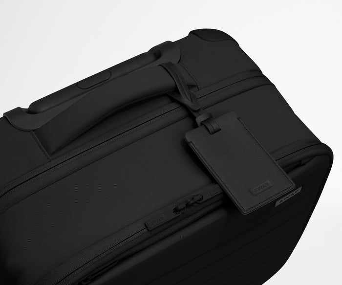 The Softside Compact Carry-On suitcase in Jet Black shown shown from above highlighting the recycled leather luggage tag
//
All Softside suitcases come with a black leather luggage tag. Add up to three letters to personalize yours and stand out at the baggage claim.
