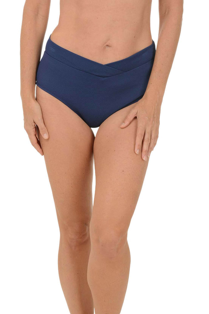 Navy blue bikini bottom worn by a person on a white background.