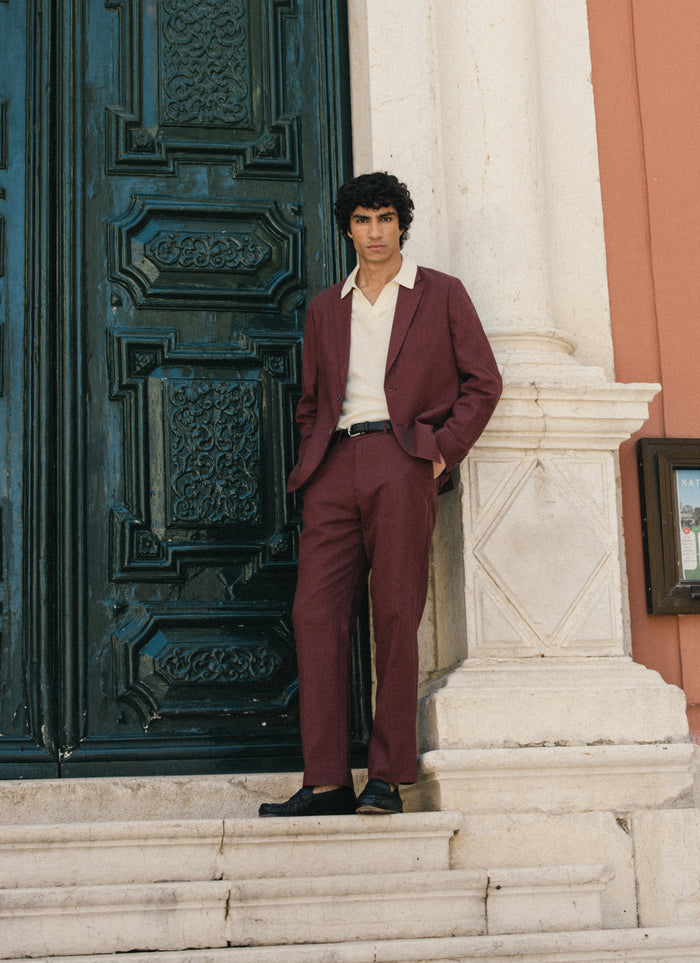 A model wears the Percival tailored linen suit in merlot, featuring straight-leg trousers and a matching blazer.